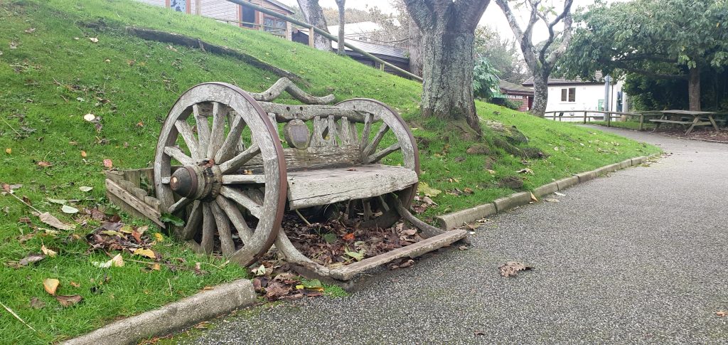 A bench made from wooden wheels and part of a cart