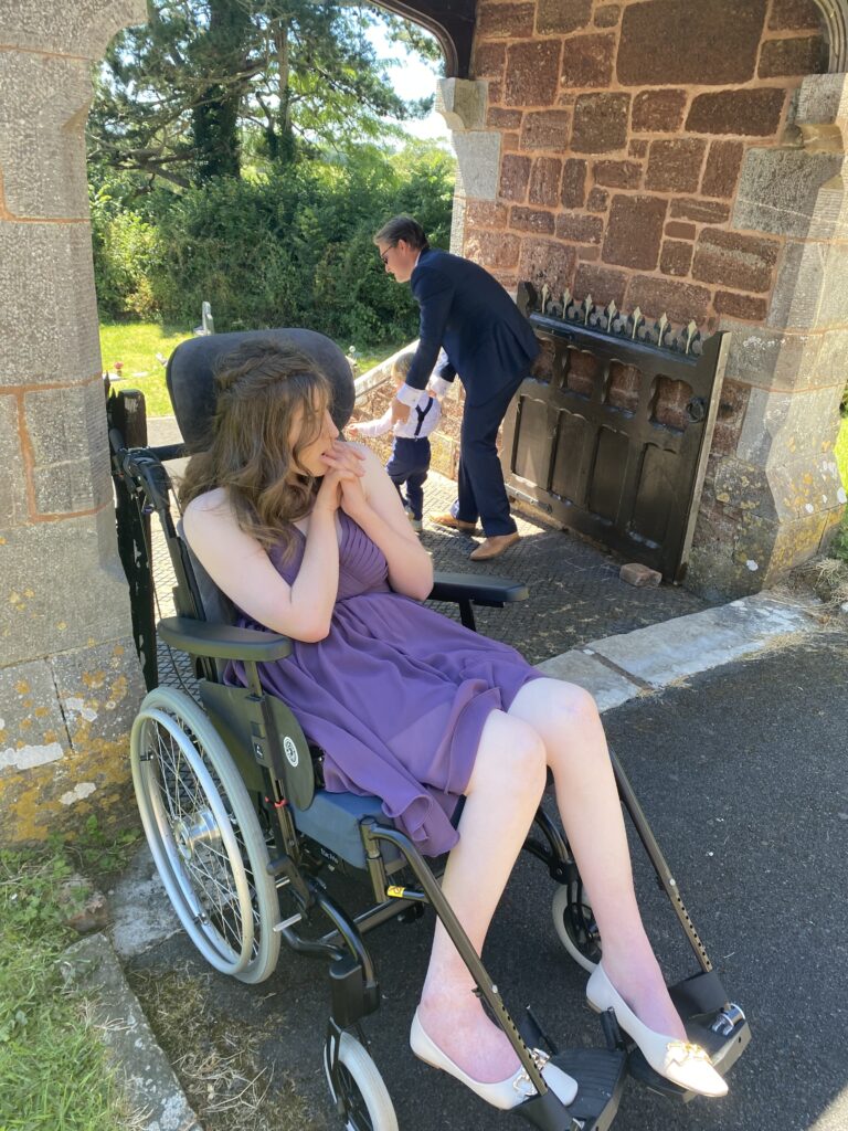 Come On Holly Pop Holly sat in her wheelchair and wearing a pretty purple dress 