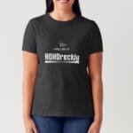 Photo of a lady with long dark hair wearing the ladies fit version of the T shirt with the design I will do it ADHDreckly and the Access Cornwall logo discreetly above