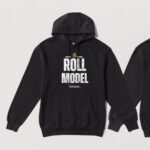 Black hoodie with the words Roll Model in large letters and a golden wheelchair above. The design is on the front of the hoodie.