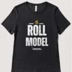 A black T shirt with the words Roll Model and a golden wheelchair above. The logo is on the front of the T shirt